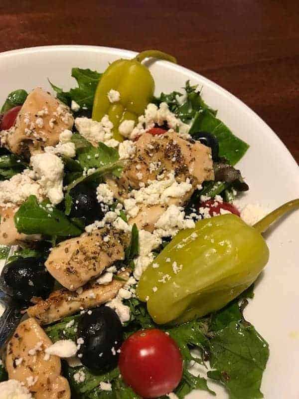 Mediterranean salad with lettuce, chicken, tomatoes, olives, pepperoncini, and feta cheese