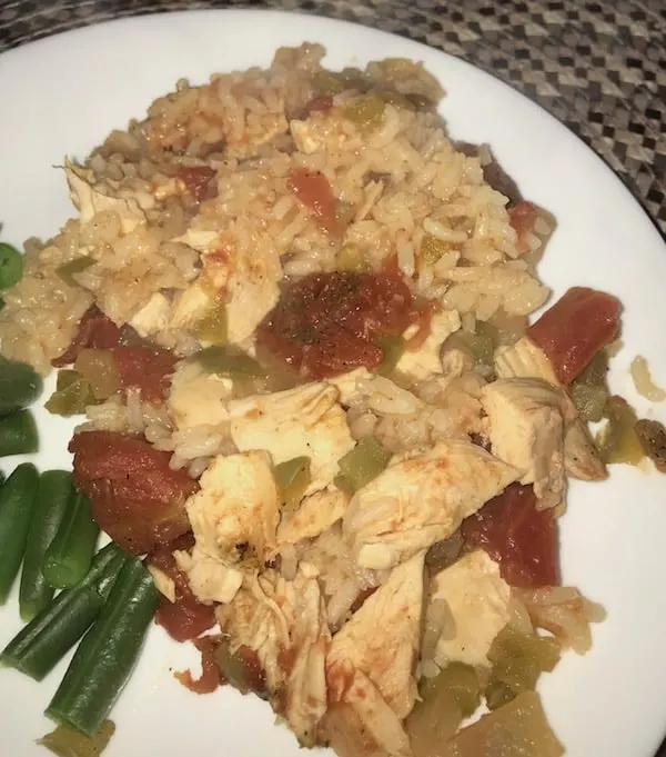 Chicken creole and green beans on a white plate