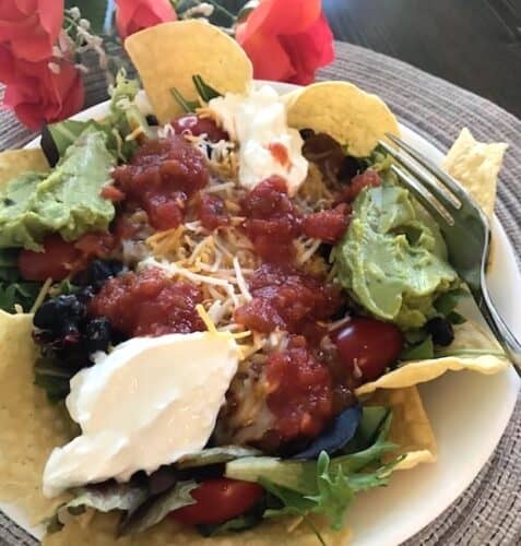 Mexican salad with tortilla chips, black beans, guacamole, and sour cream