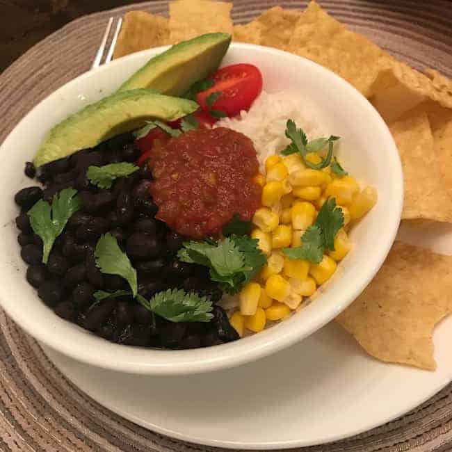 Rice bowl with vegetables and a side of chips