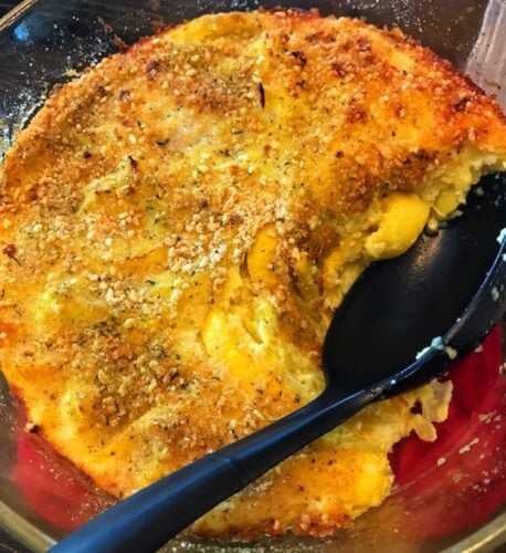 pan of squash casserole with a serving spoon