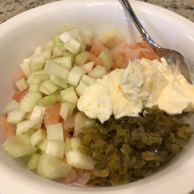 Mayonnaise, sweet pickle relish, and celery added to shrimp to make creamy shrimp salad