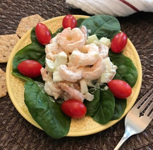 Shrimp salad on a bed of spinach leaves with tomatoes