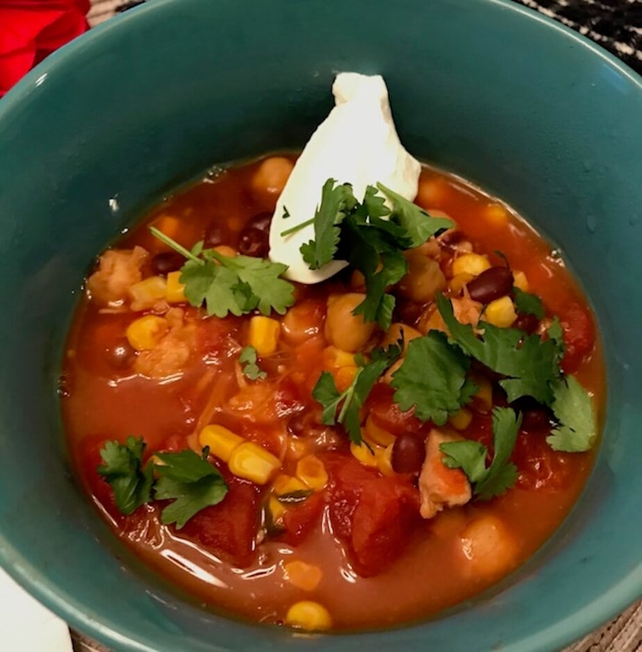 bowl of taco soup with chopped cilantro and a spoonful of sour cream