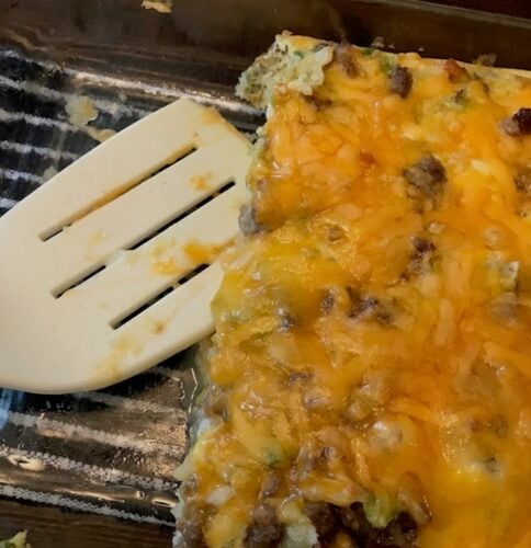 breakfast tater tot casserole in serving dish with white spatula