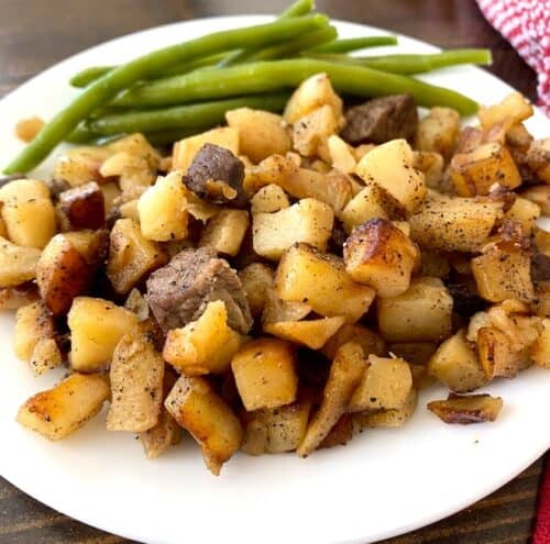beef hash on a plate with green beans