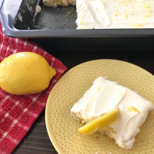 Lemon bar on a plate beside a lemon