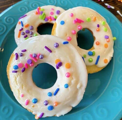 3 frosted donuts with sprinkles on a plate