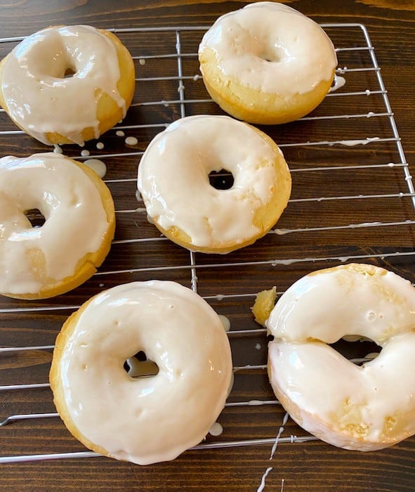 Frosted donuts on a baking rack