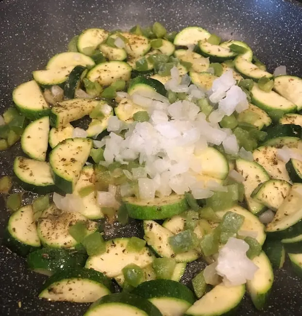 Zucchini, onions, and peppers in a pan