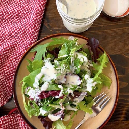 Buttermilk ranch dressing on a salad beside a jar of dressing