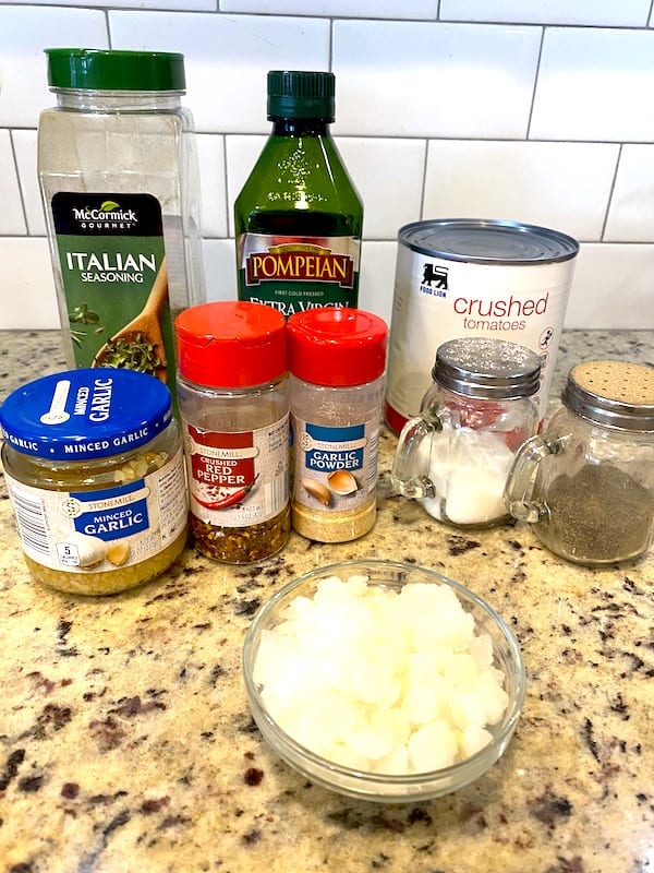 Crushed tomatoes, Italian seasoning, olive oil, minced garlic, red pepper flakes, garlic powder, chopped onions, salt, and pepper