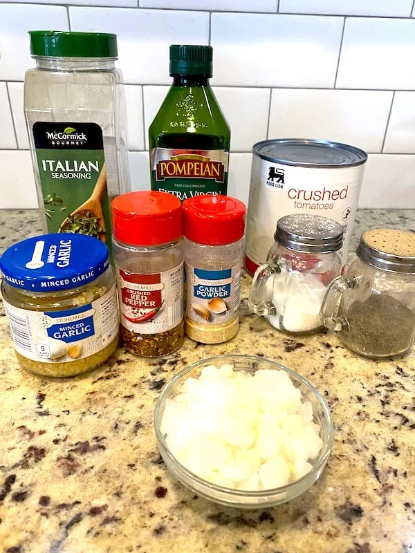 Crushed tomatoes, Italian seasoning, olive oil, minced garlic, red pepper flakes, garlic powder, chopped onions, salt, and pepper