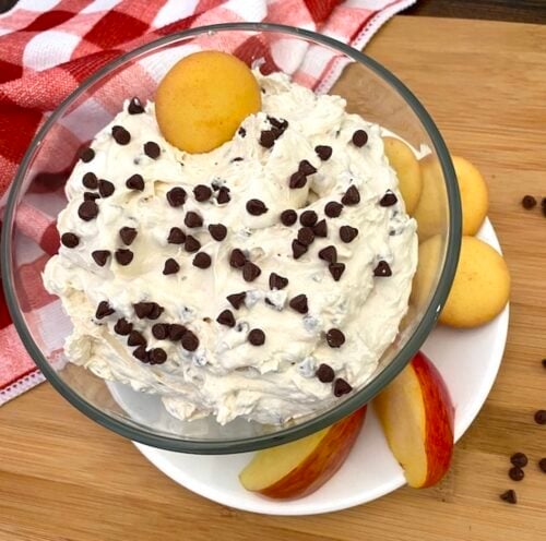 bowl of chocolate chip fluff dip with apple slices and cookies