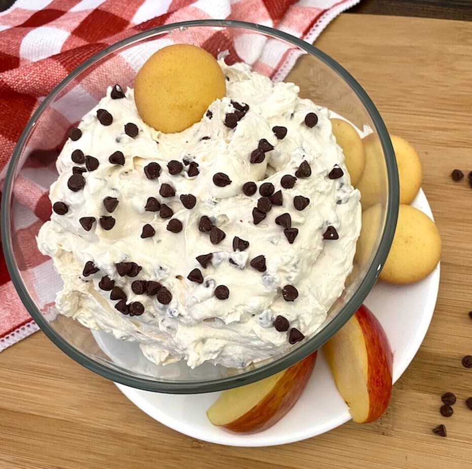 bowl of chocolate chip fluff dip with apple slices and cookies