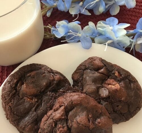 plate of brownie pecan cookies beside a glass of milk