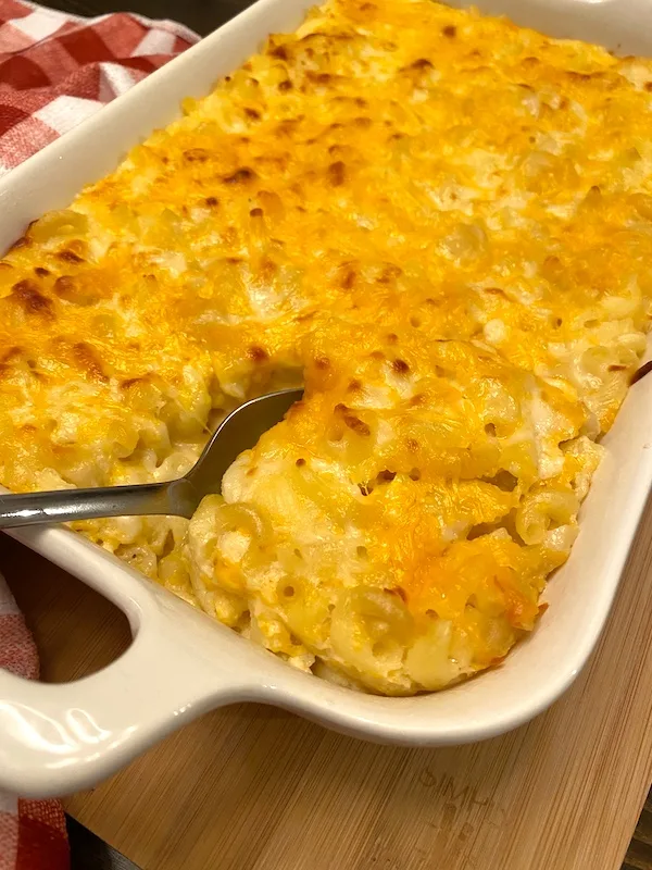 scooping a serving of classic baked mac and cheese