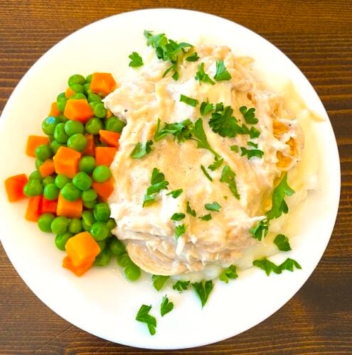 Chicken and gravy with a side of peas and carrots