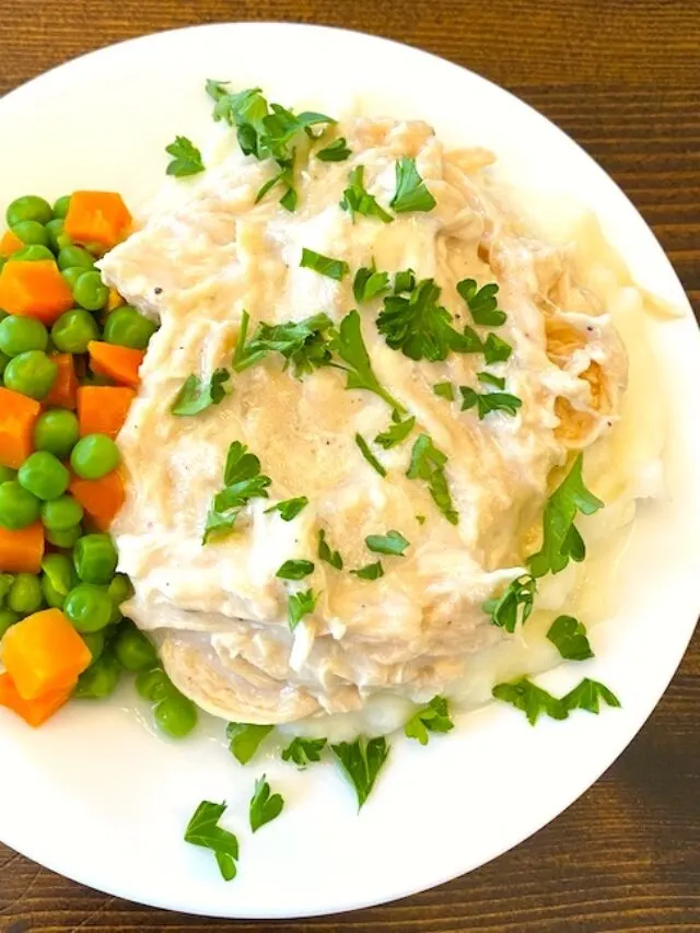 Chicken and gravy with a side of peas and carrots