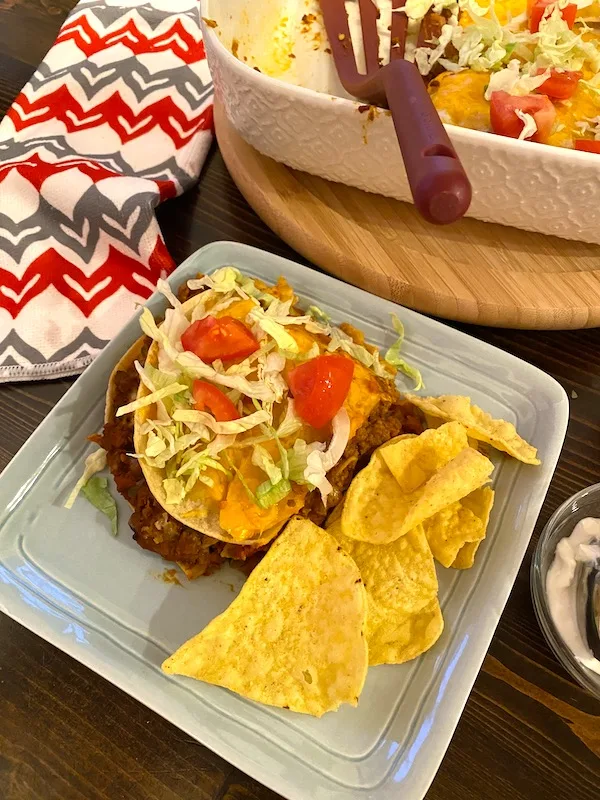 beef and bean enchilada on a plate next to a casserole dish