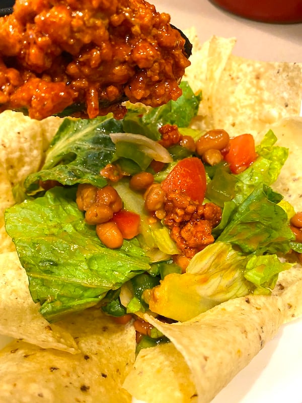 adding taco meat to salad ingredients