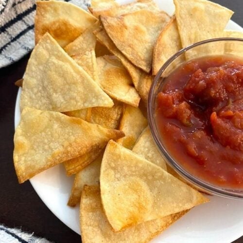 plate of corn tortilla chips and a bowl of salsa