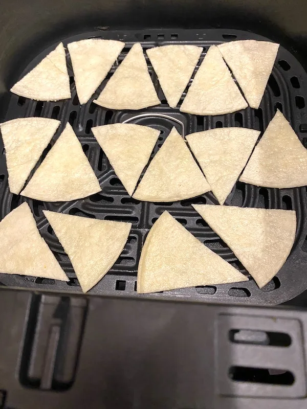 tortilla wedges in an air fryer basket