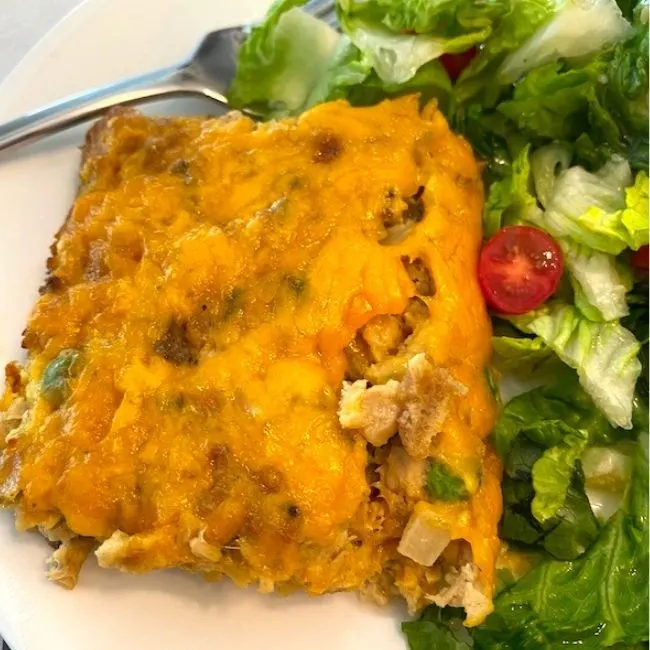 slice of salmon casserole on a plate with a salad