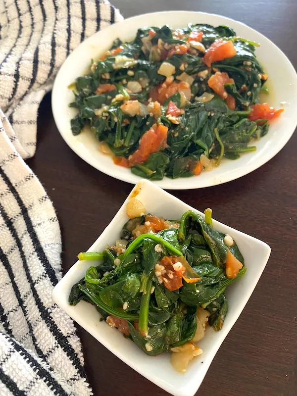 serving bowl and plate with spinach and tomatoes