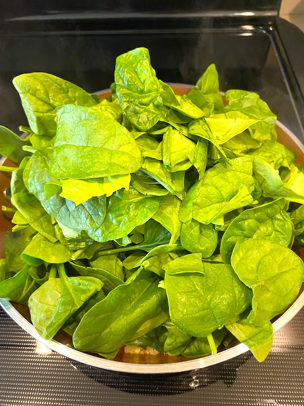 fresh spinach added to the pan