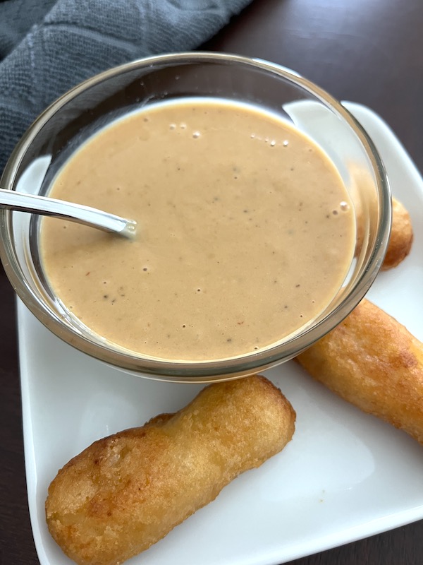 bowl of Chick Fil A sauce with chicken tenders on a plate