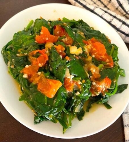 bowl of sautéed spinach and tomatoes