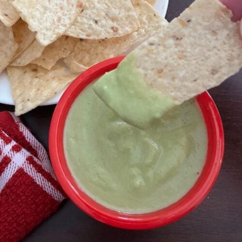 bowl of taco truck green sauce with chips