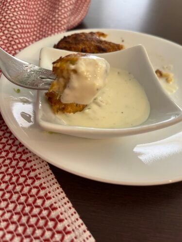 lemon dill cream sauce on a plate with crab cake