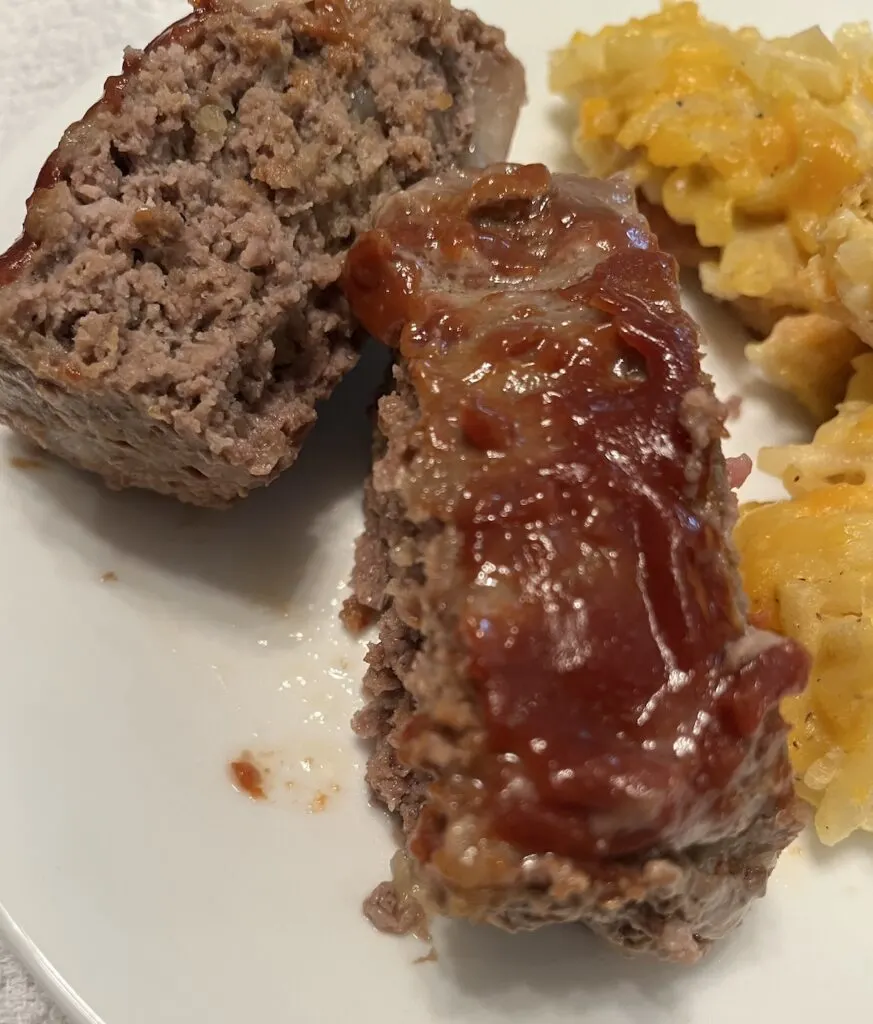 slices of meatloaf on a plate with cheesy potatoes