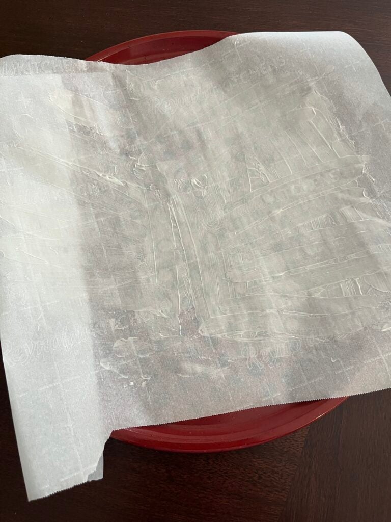 buttered parchment paper on pizza pan