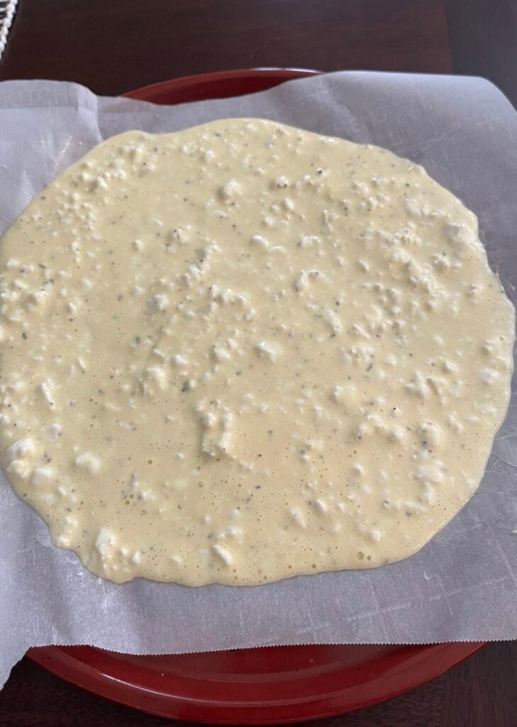 low-carb pizza crust mixture on parchment lined pizza pan