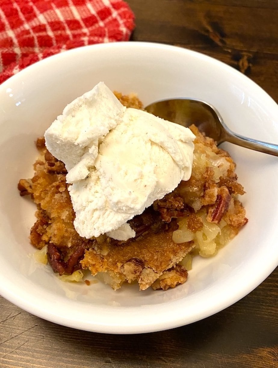 bowl of pineapple dump cake with ice cream on top