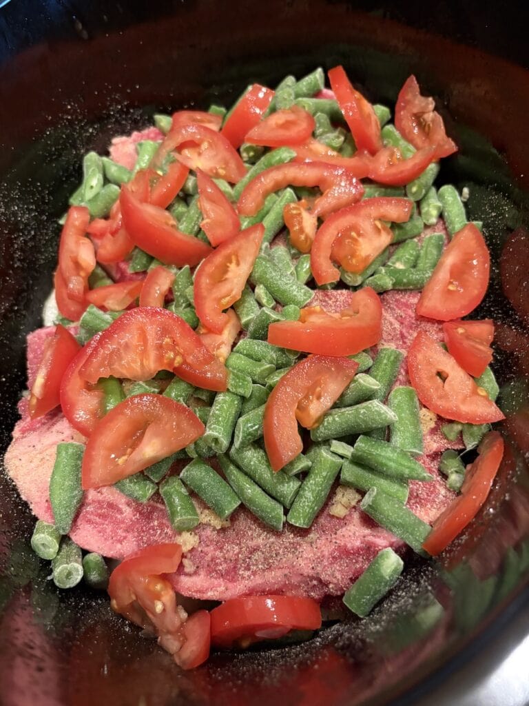 tomatoes and green beans in crock pot with chuck steak and onions