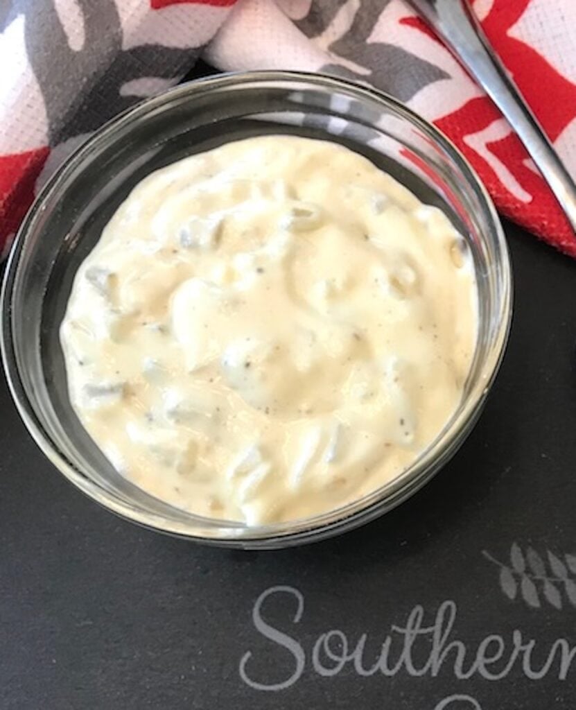 bowl of tartar sauce and spoon on a dishtowel
