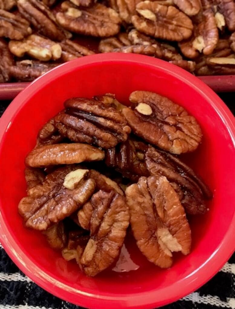 roasted pecans in a small red bowl