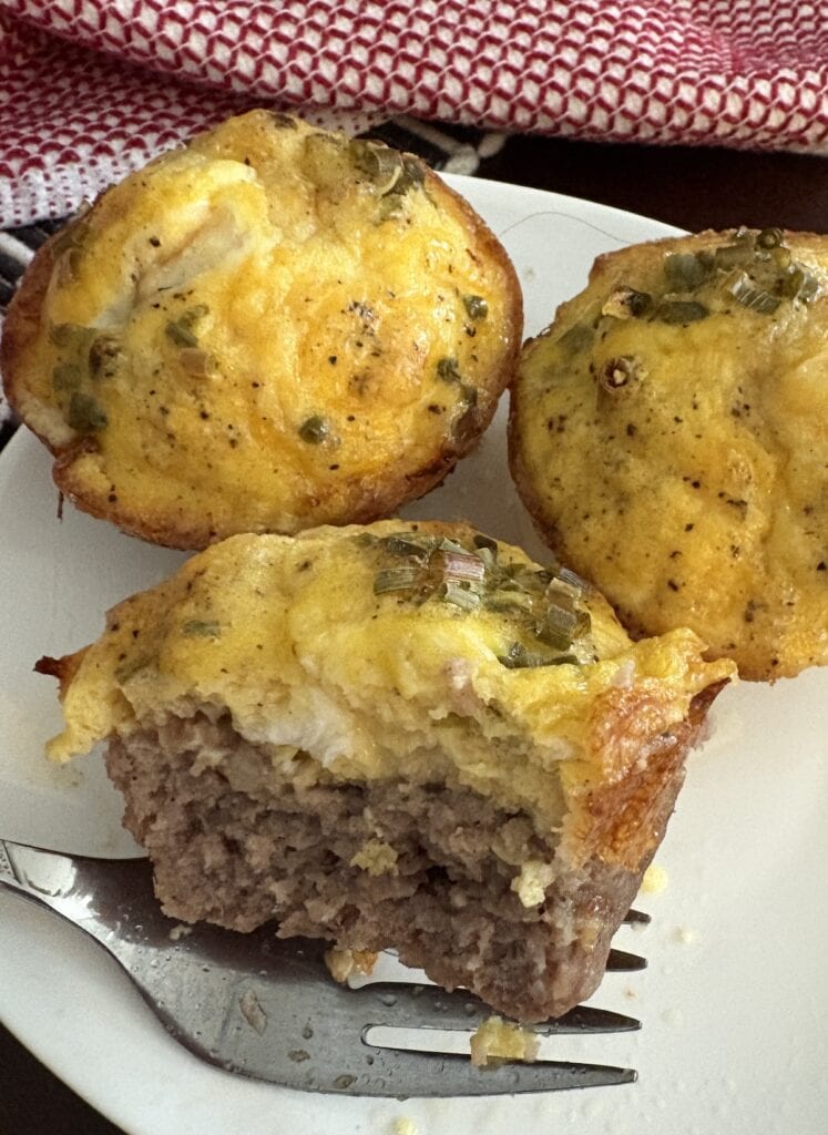 side of a sausage cup with egg and cheese on a fork