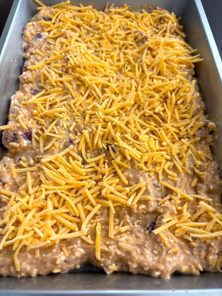 shredded cheese on chili cheese dip mixture