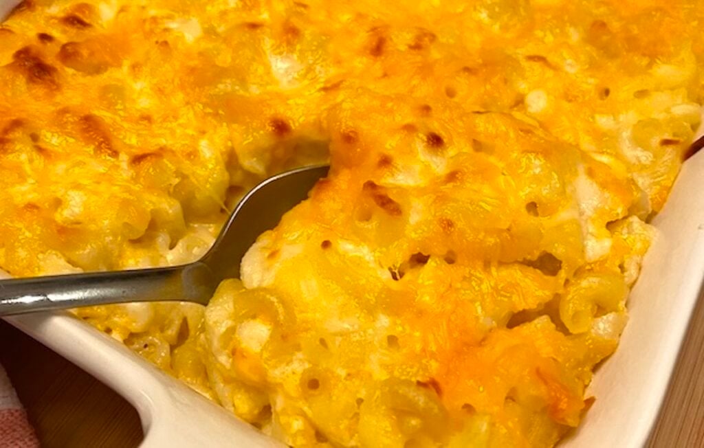scooping mac and cheese casserole with a serving spoon