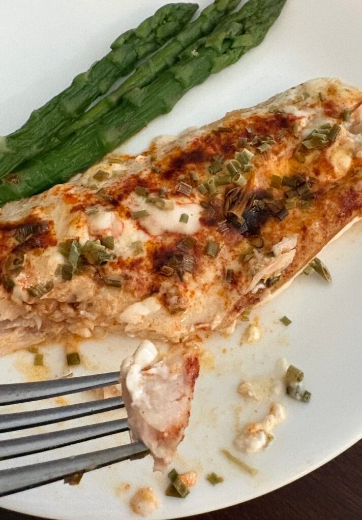 fork of fish over plate of baked ranch fish and asparagus