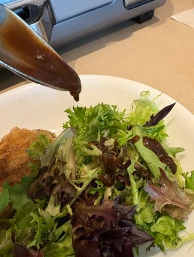 drizzling balsamic vinaigrette over salad